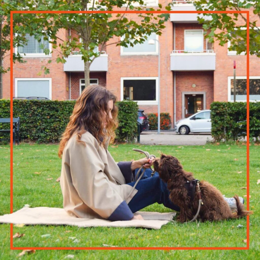 Kvinde sidder med sin hund i en park.