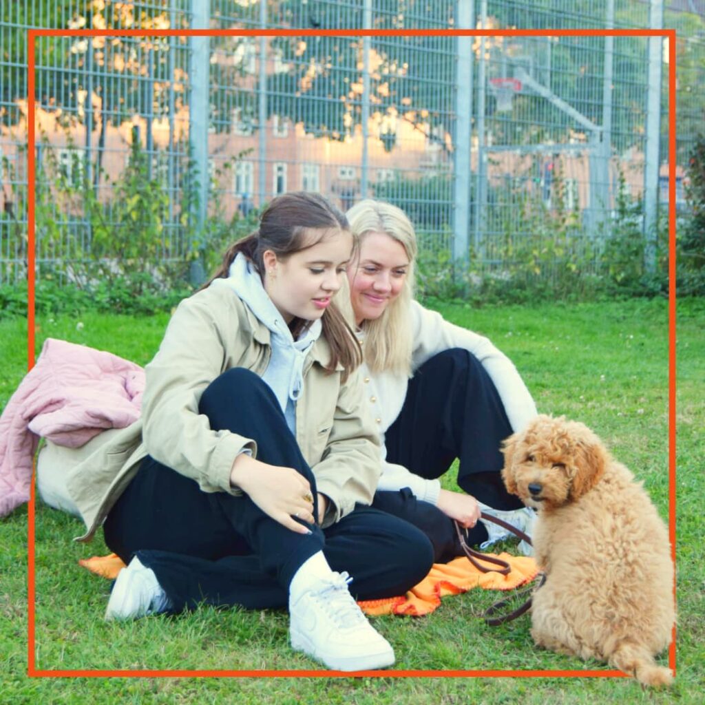 En kvindes og hendes datter træner med deres hund til hundetræning hos klub hund.